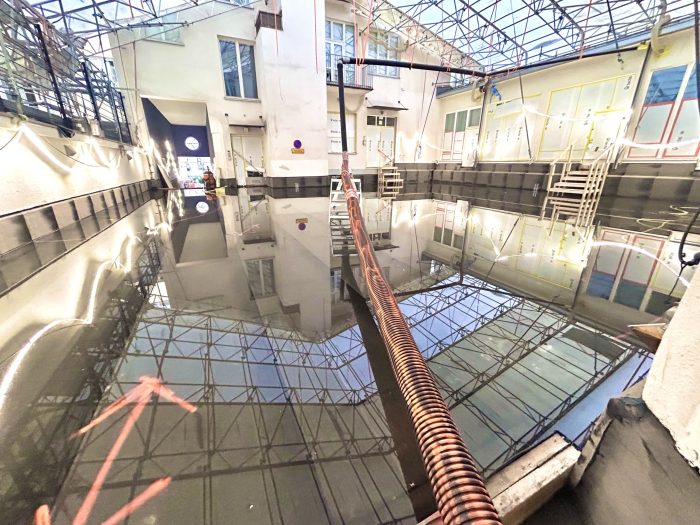 Pihakansiremontin valvoja suorittamassa vedenpainekoetta pihakannen vedeneristeille.