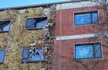 Kerrostalon julkisivun korjaustyö, tiiliverhous osittain purettu