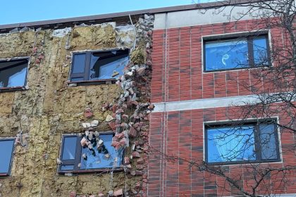 Kerrostalon julkisivun korjaustyö, tiiliverhous osittain purettu